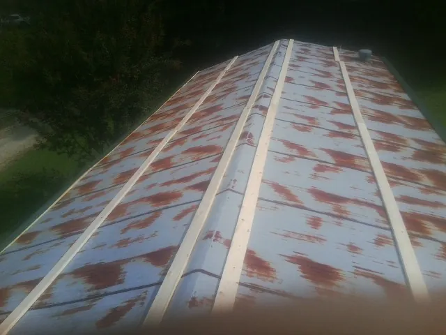 Rusted metal roof panels with new wood purlins before replacement — Storm Damage Roof Repair in Flint by Roofing Brothers