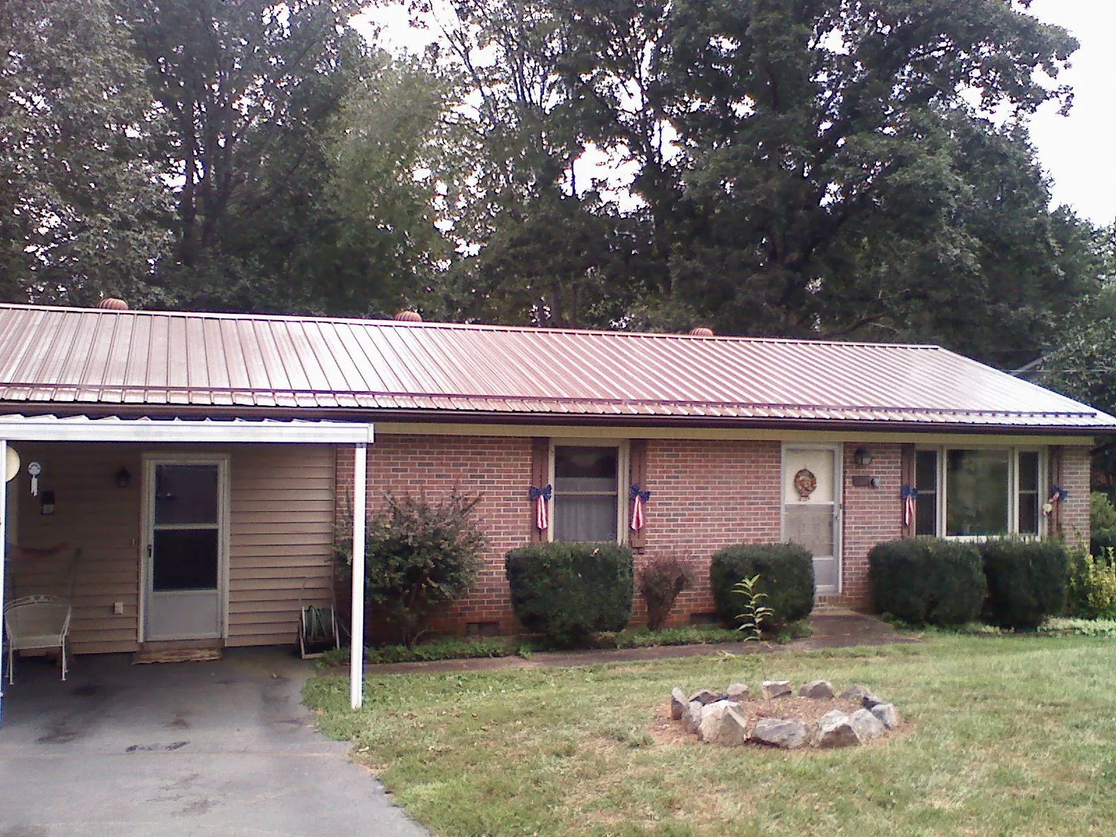 Bronze metal roof and carport on a brick ranch home — Roof Repair work by our crew in Flint