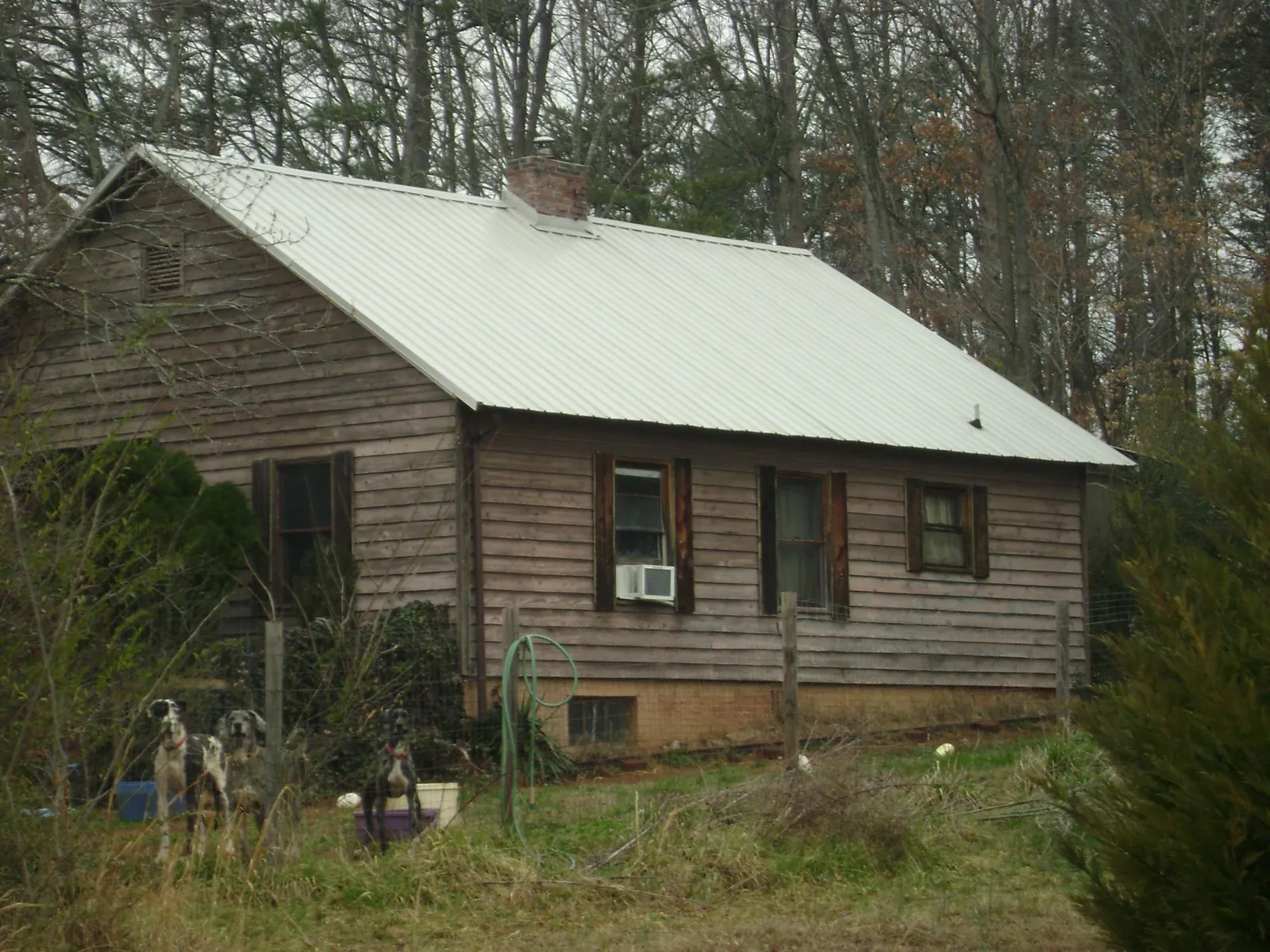 White metal roof on an old wood sided farmhouse, from a Metal Roof Installation job in Flint